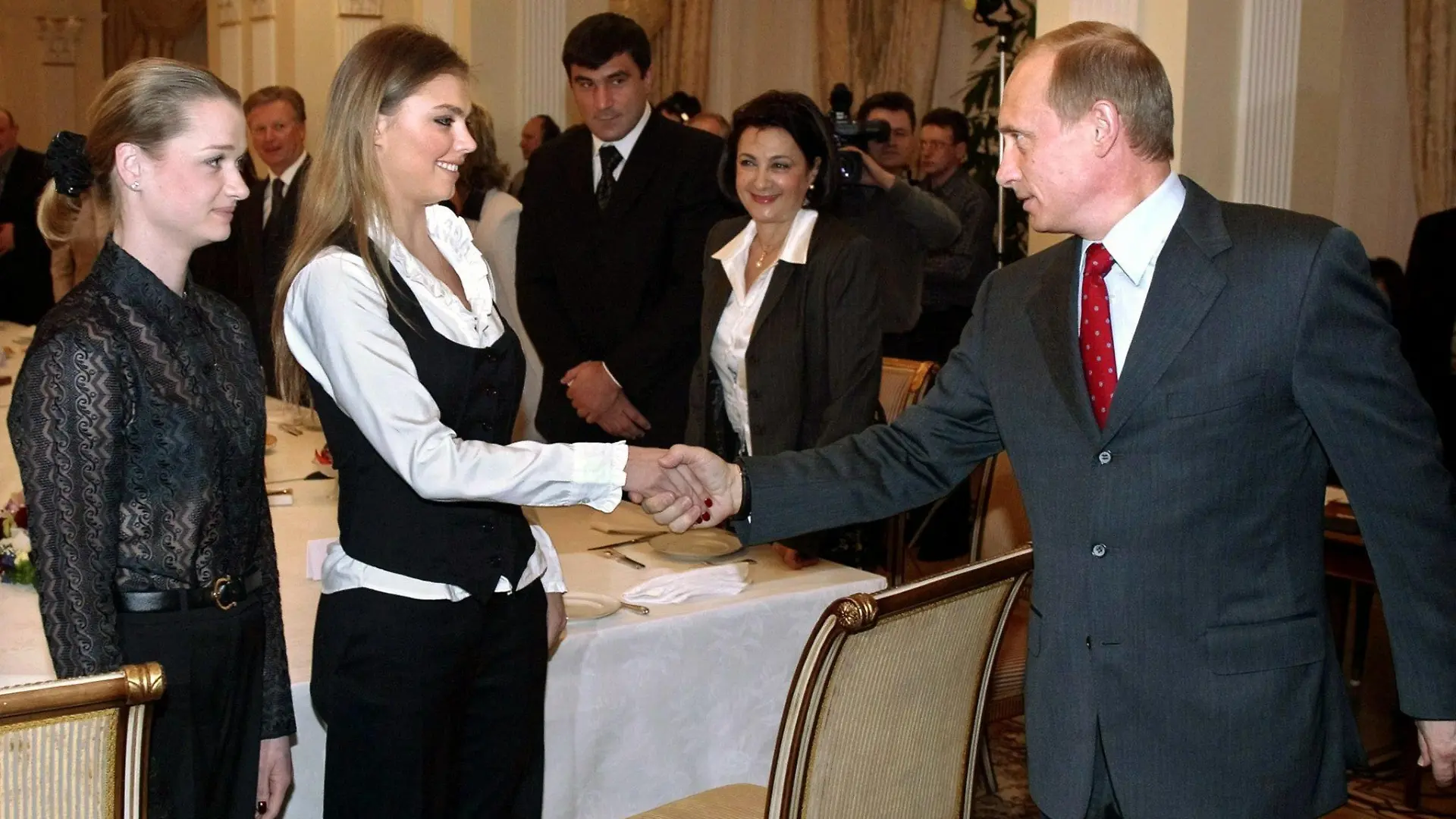ARCHIV - Der russische Präsident Wladimir Putin begrüßt am 10.03.2004 die Sportgymnastin Alina Kabajewa (M) und die Turnerin Swetlana Chorkina während eines Treffens mit Sportlern, die an den Olympischen Spielen in Athen teilnehmen sollen. In Russland hat ein Zeitungsbericht über eine angebliche Scheidung von Präsident Wladimir Putin sowie eine bevorstehende Hochzeit mit einer 31 Jahre jüngeren Olympiasiegerin für Verwirrung gesorgt. Der Pressedienst des Kremls wollte am Dienstag (15.04.2008) keinen Kommentar zum Bericht der Boulevardzeitung «Moskowski Korrespondent» abgeben, die von Plänen für eine Heirat Putins (55) mit der ehemaligen Sportgymnastin Alina Kabajewa (24) im Juni erfahren haben will. Das Blatt hatte am Freitag unter Berufung auf eingeweihte Kreise in Putins Heimatstadt St. Petersburg geschrieben, Putin habe sich bereits im Februar von seiner Frau Ljudmila scheiden lassen. EPA/SERGEI CHIRIKOV +++(c) dpa - Bildfunk+++