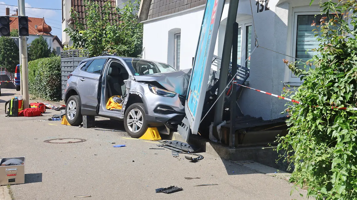Ein verunfalltes Auto an einer Hauswand.