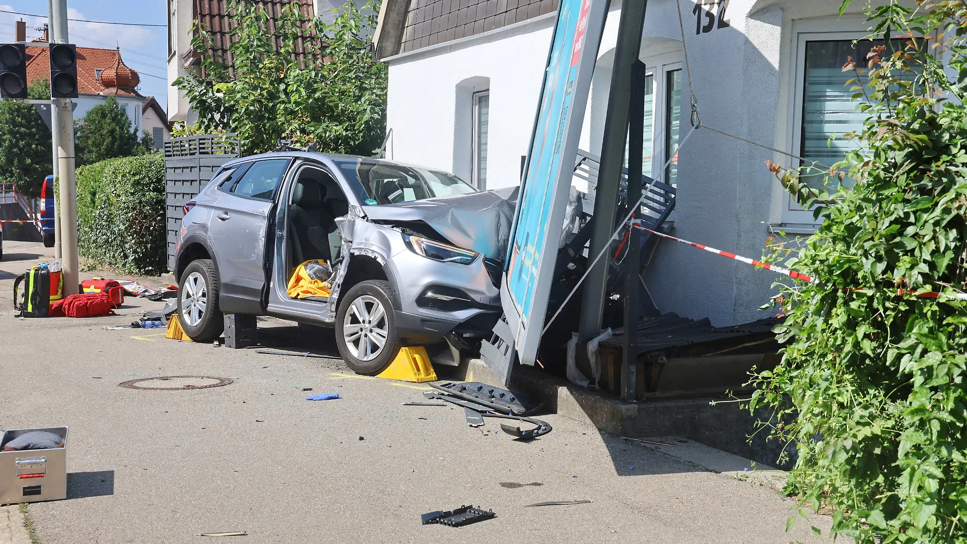 Ein verunfalltes Auto an einer Hauswand.