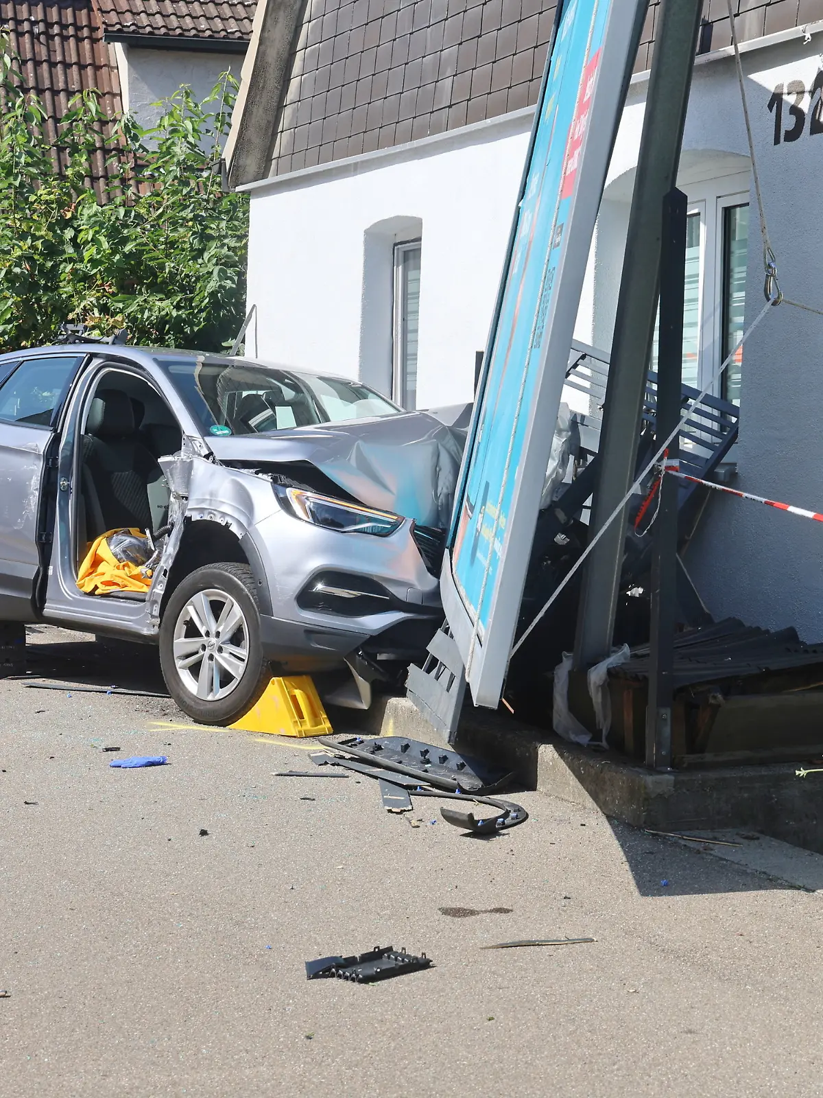 Ein verunfalltes Auto an einer Hauswand. 