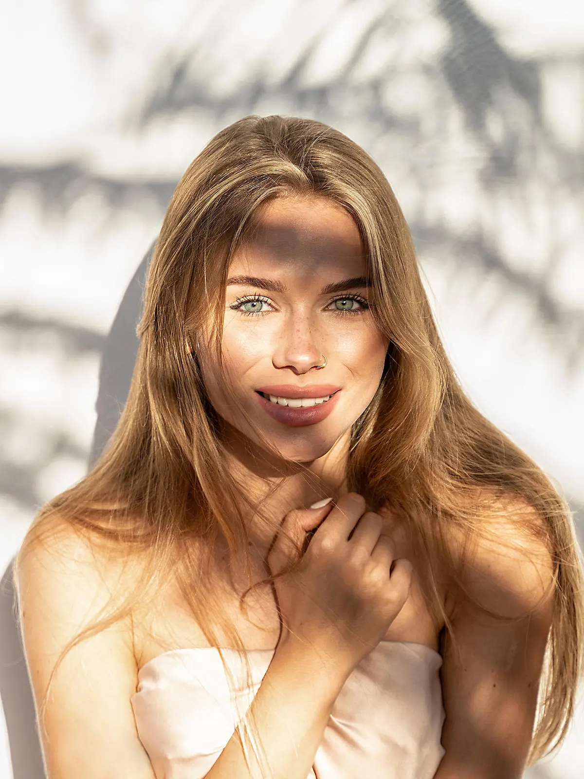 Lovely beautiful young blonde woman with natural freckles smiling to the camera. Natural shadows. A lot of copy space.