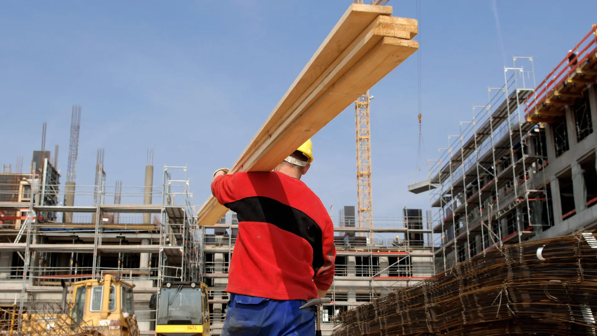 ARCHIV - Ein Arbeiter des Subunternehmens "Polbau" trägt am 06.04.2005 auf eine Baustelle im hessischen Eschborn Holzlatten auf der Schulter. Am Donnerstag (28.07.2011) gibt die Bundesagentur in Nürnberg die Arbeitsmarktdaten für den Monat Juli 2011 bekannt. Foto: Arne Dedert dpa/lby +++(c) dpa - Bildfunk+++