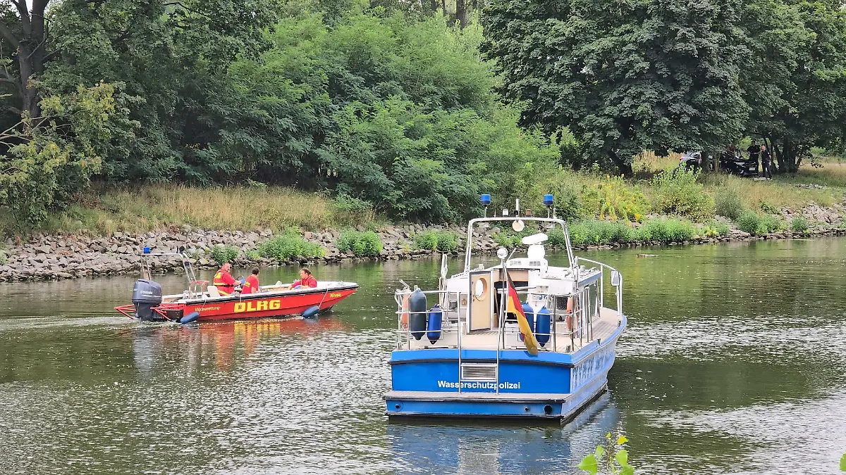 In Brandenburg/Havel fahren Boote der Wasserschutzpolizei und der DLRG auf dem Silokanal, nachdem hier eine Leiche gefunden wurde.
