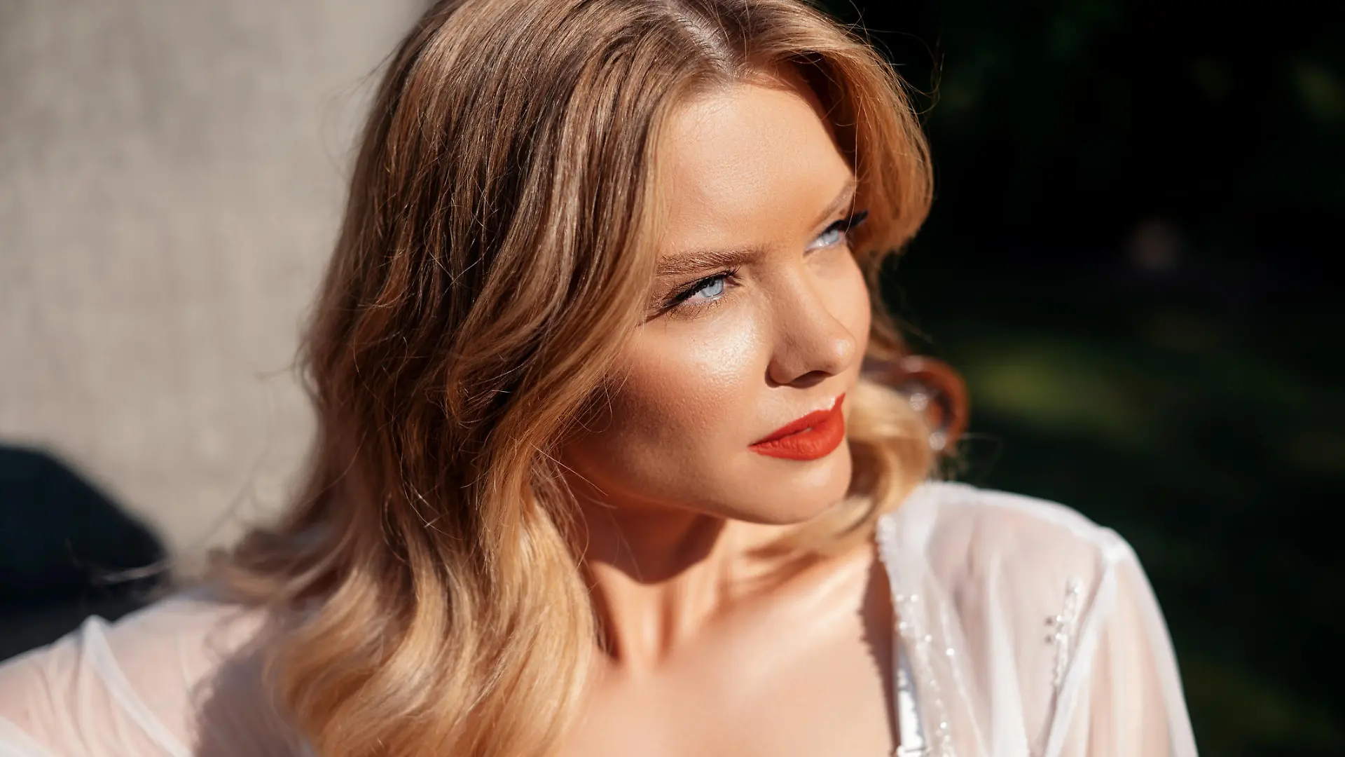 Portrait of attractive young woman with blue eyes and blond hair posing on nature. Stunning bride having wedding makeup and hairstyle. Concept of people, event and celebration.