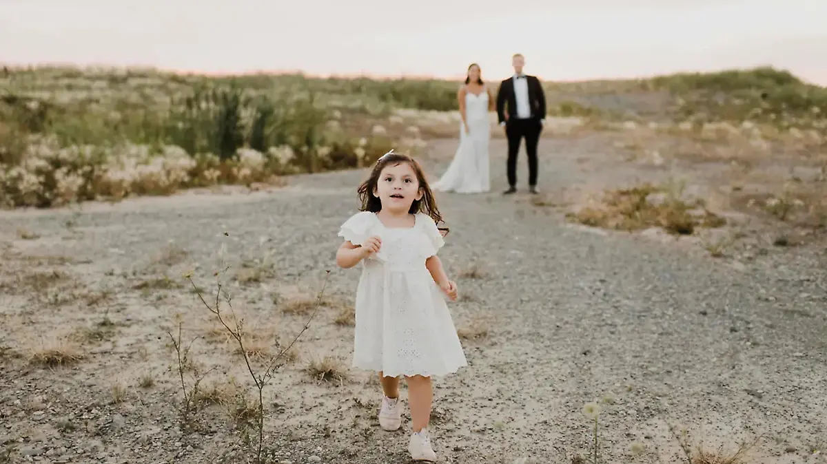 Kleines Mädchen läuft vor Hochzeitpaar