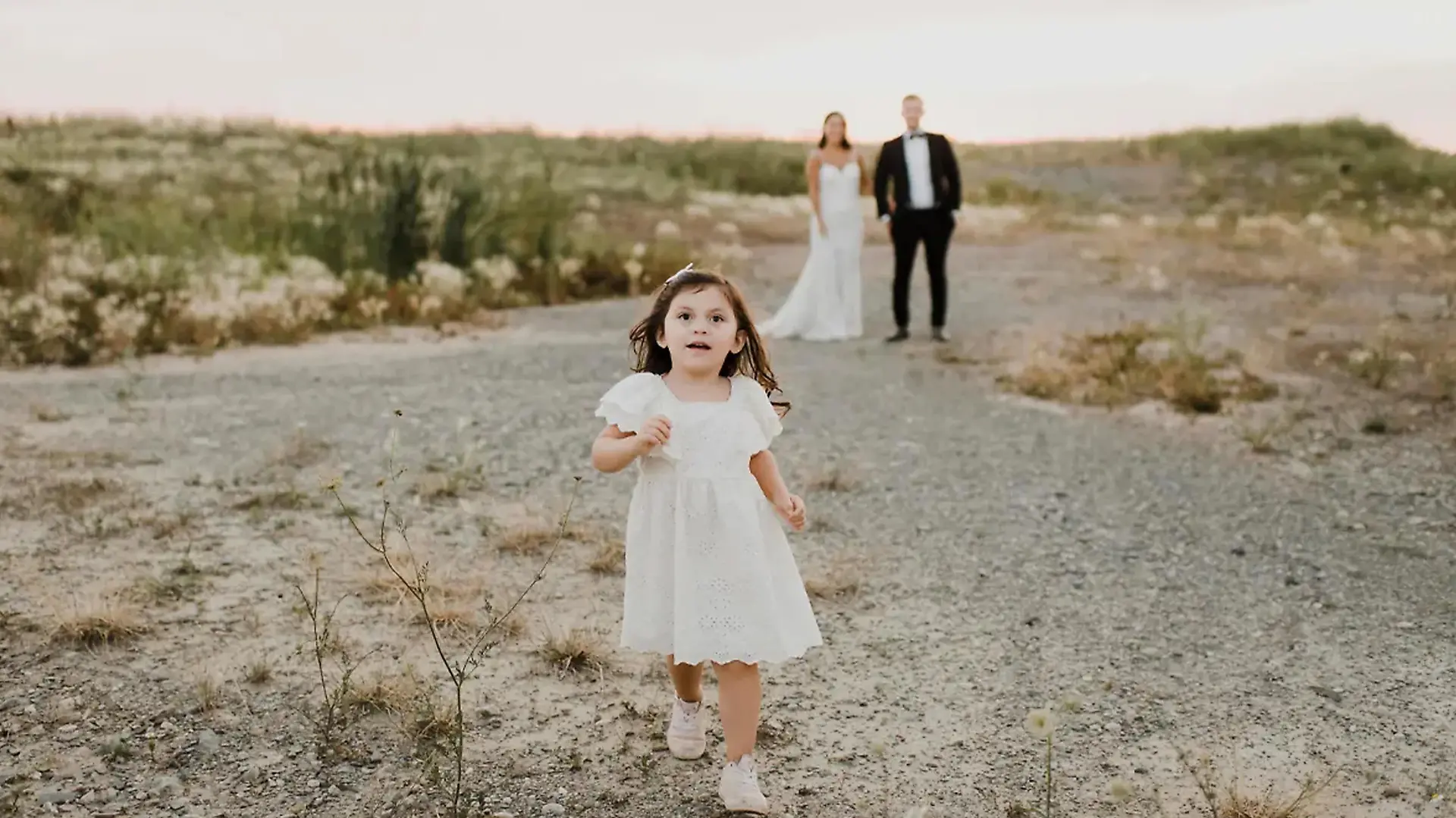 Kleines Mädchen läuft vor Hochzeitpaar