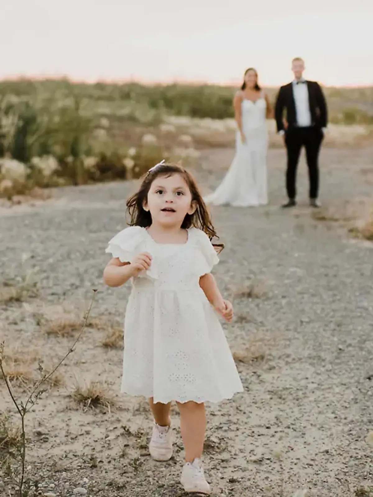 Kleines Mädchen läuft vor Hochzeitpaar