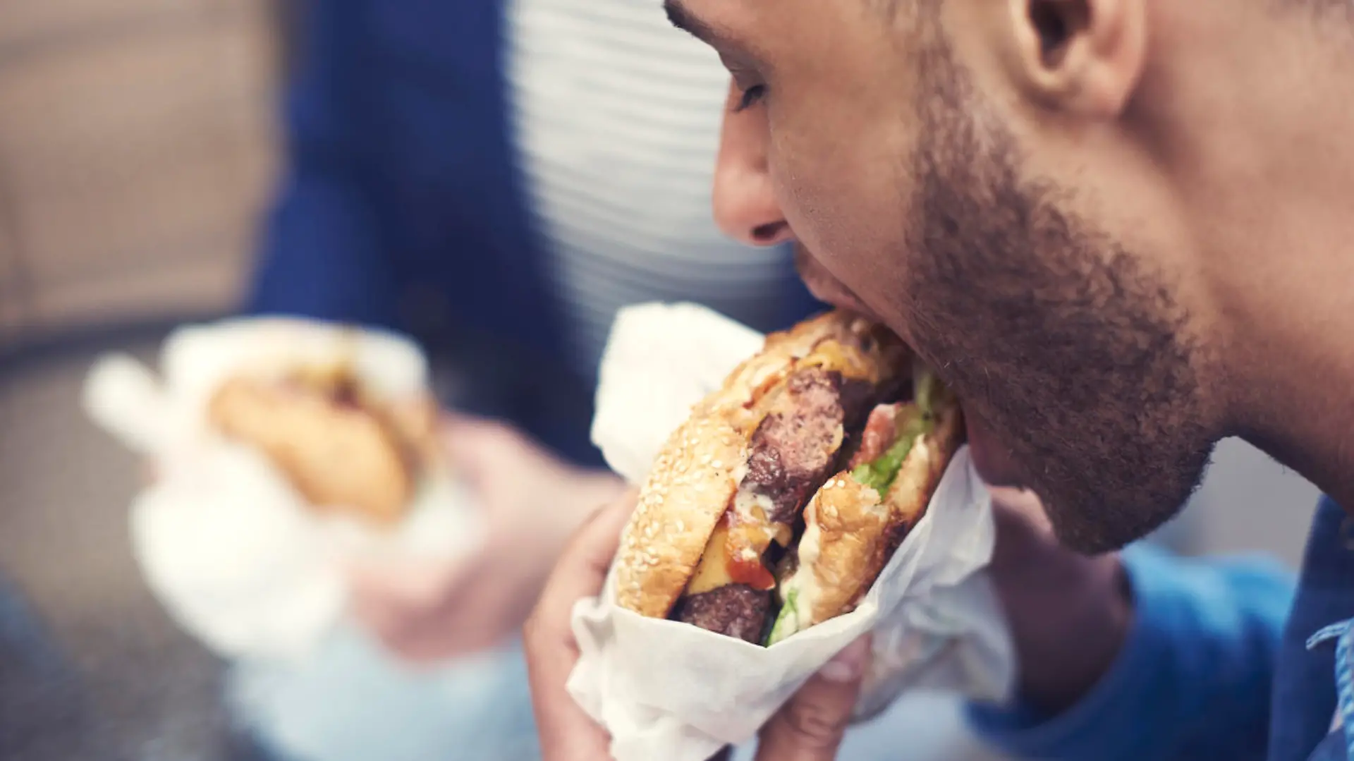 Close up of man eating cheeseburger