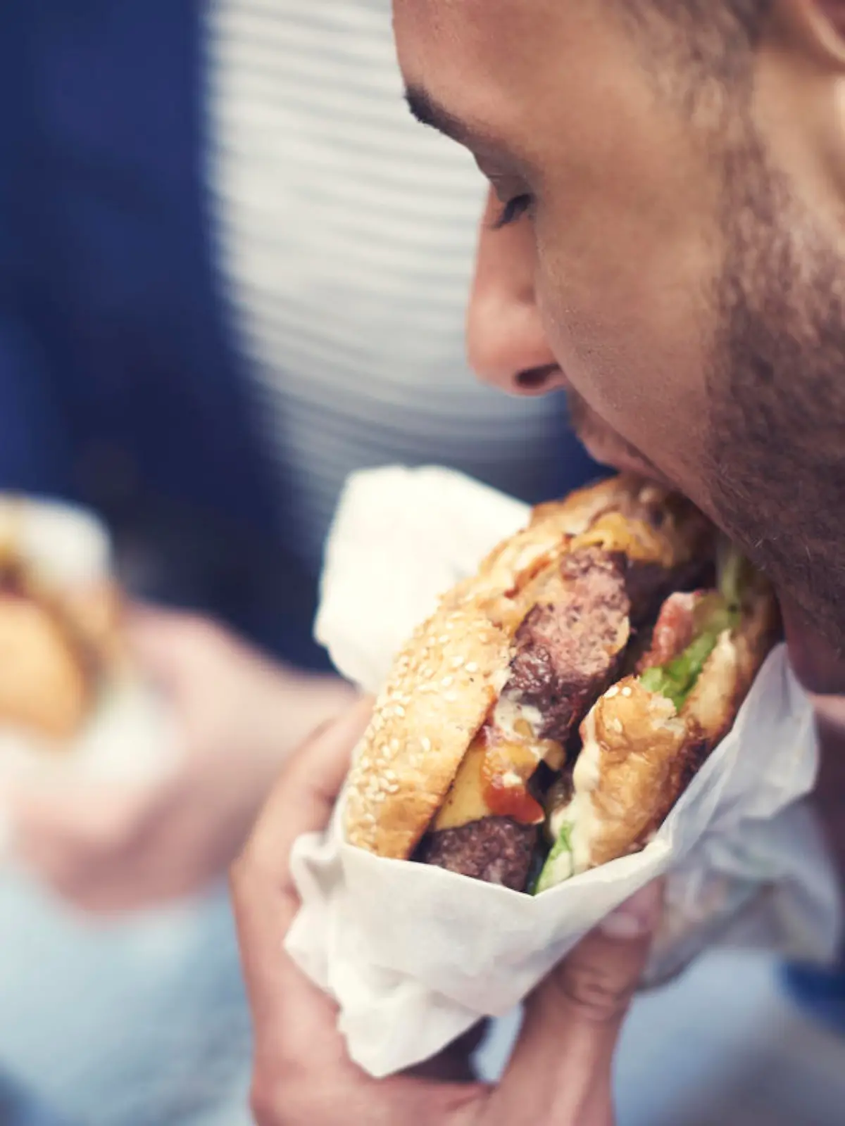 Close up of man eating cheeseburger