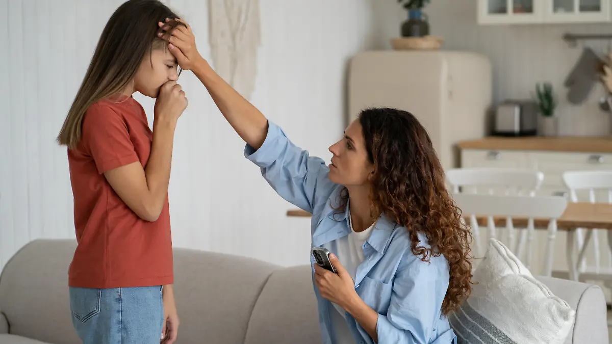 Kind krank? Mutter fasst Tochter an die Stirn.