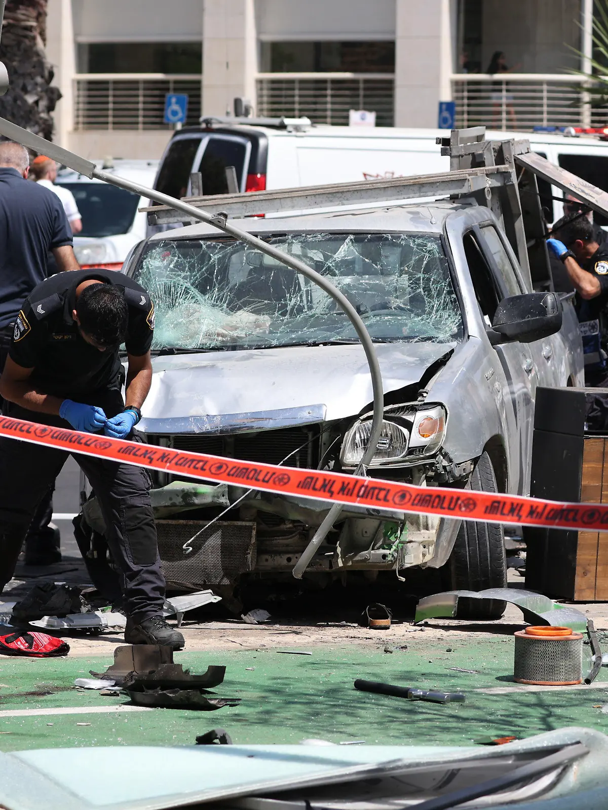 04.07.2023, Israel, Tel-Aviv: Israelische Sicherheits- und Rettungskräfte inspizieren den Ort eines Anschlags mit einem Auto in Tel Aviv. Bei einem mutmaßlichen Anschlag, bei dem ein Auto in eine Gruppe von Fußgängern fuhr, sind mehrere Menschen verletzt worden, teilte der israelische Rettungsdienst Magen David Adom mit. Foto: Ilia Yefimovich/dpa +++ dpa-Bildfunk +++