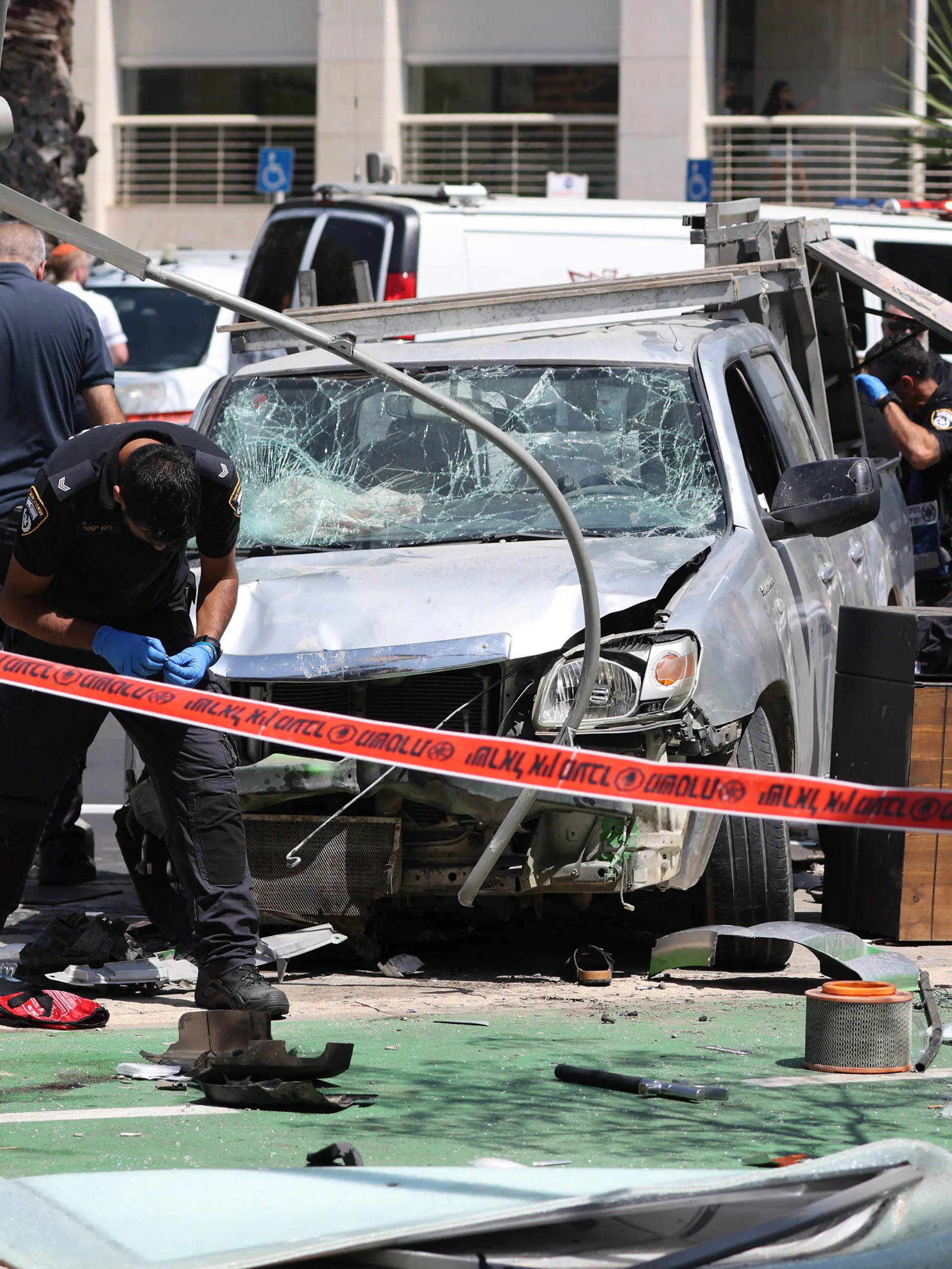 04.07.2023, Israel, Tel-Aviv: Israelische Sicherheits- und Rettungskräfte inspizieren den Ort eines Anschlags mit einem Auto in Tel Aviv. Bei einem mutmaßlichen Anschlag, bei dem ein Auto in eine Gruppe von Fußgängern fuhr, sind mehrere Menschen verletzt worden, teilte der israelische Rettungsdienst Magen David Adom mit. Foto: Ilia Yefimovich/dpa +++ dpa-Bildfunk +++