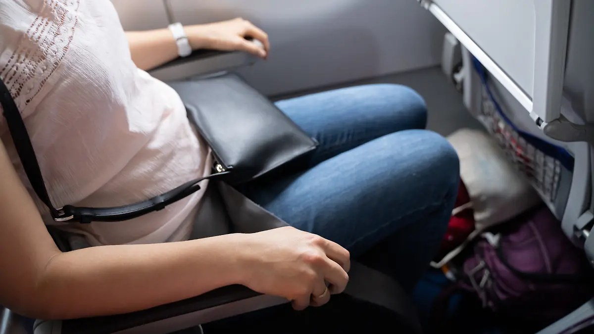 Eine Frau sitzt im Flugzeug. 