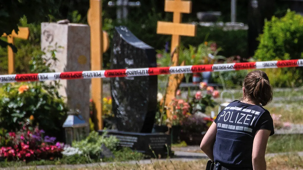 09.06.2023, Baden-Württemberg, Altbach: Eine Polizistin geht über den abgesperrten Teil an einem Tatort auf einem Friedhof. Durch den Wurf eines explodierenden Gegenstands auf eine Trauergemeinde gab es mehrere Verletzte. (Wiederholung mit verändertem Bildausschnitt) Foto: Christoph Schmidt/dpa +++ dpa-Bildfunk +++