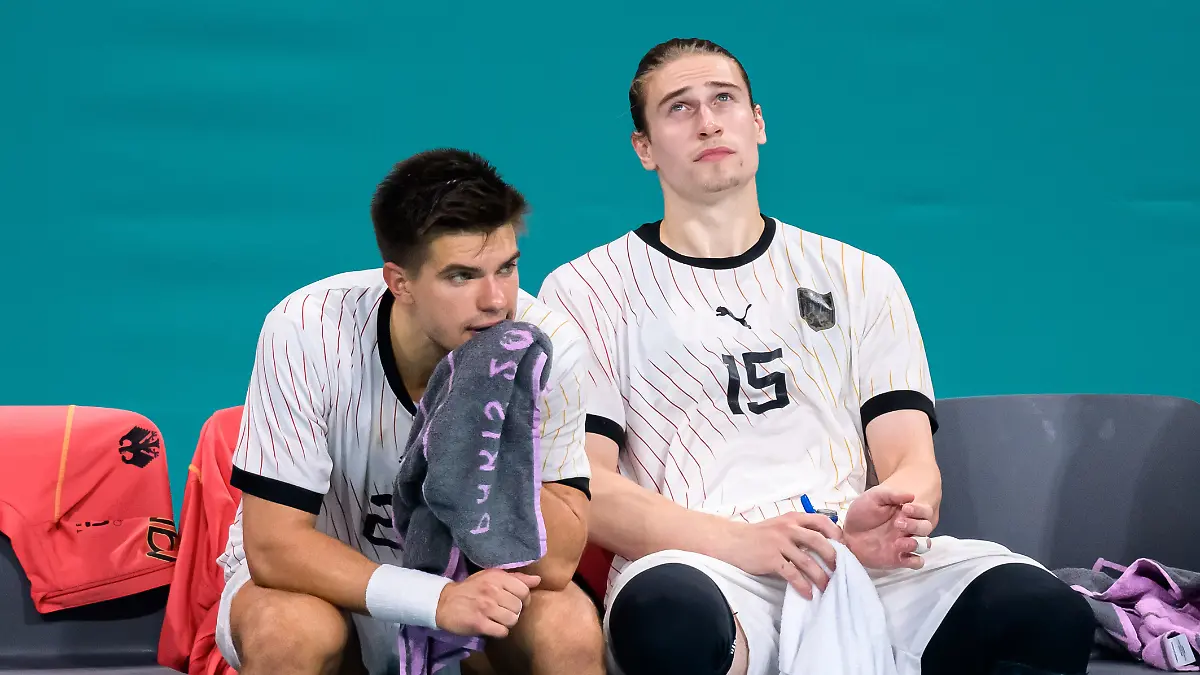 Renars Uscins und Juri Knorr sitzen nach der Finalniederlage bei den Olympischen Spielen enttäuscht auf der Bank.