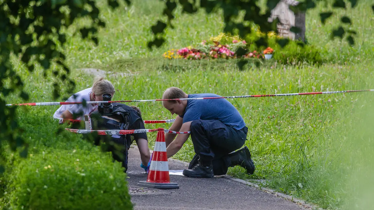 09.06.2023, Baden-Württemberg, Altbach: Mitarbeiter der Spurensicherung suchen nach Spuren an einem Tatort auf einem Friedhof. Durch den Wurf eines explodierenden Gegenstands auf eine Trauergemeinde gab es mehrere Verletzte. Foto: Christoph Schmidt/dpa +++ dpa-Bildfunk +++