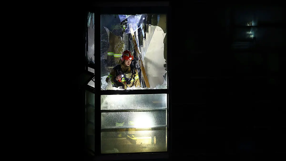 22.08.2024, Südkorea, Bucheon: Ein Feuerwehrmann sucht nach einem Brand in einem Hotel in Bucheon nach vermissten Personen.
