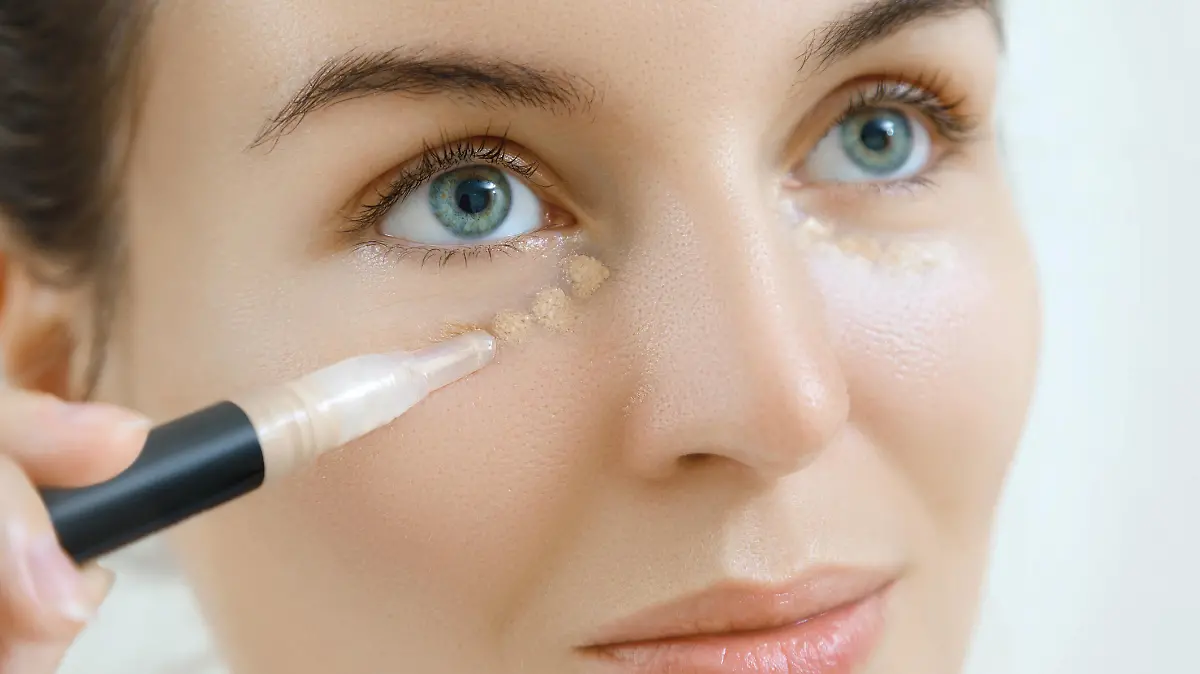 Woman using concealer for under eye circles