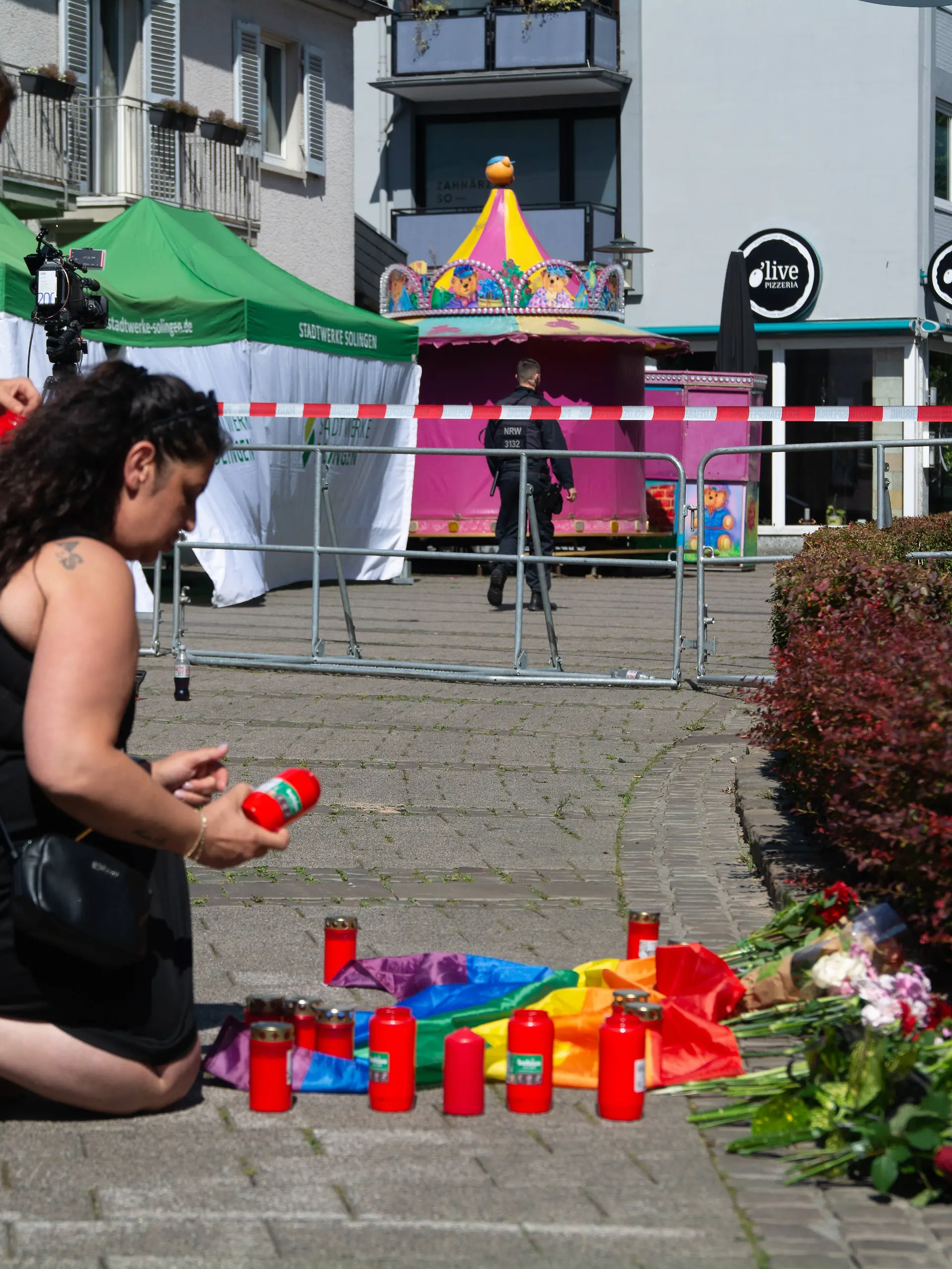 After Solingen Stabbing Attack In Solingen Two women bring candle lights for the victims as police seal off the stabbing