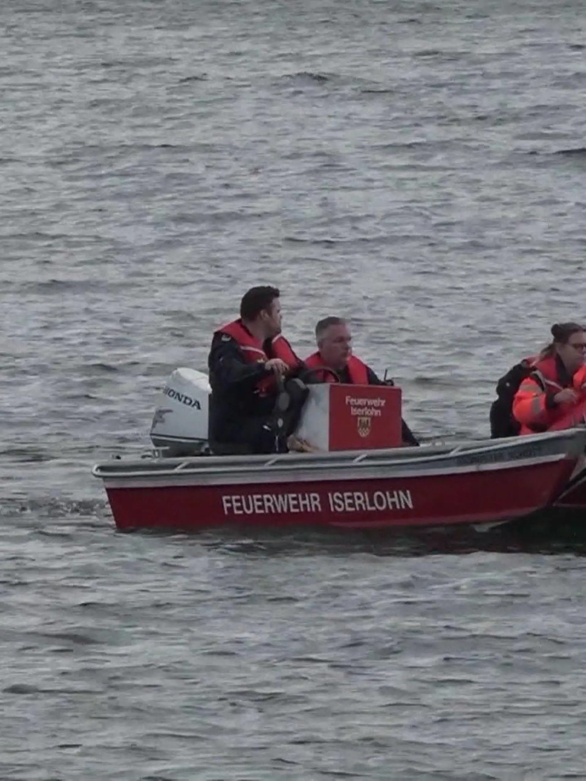 Ein Boot der Feuerwehr Iserlohn fährt mit einem Suchhund an Bord auf dem See.
