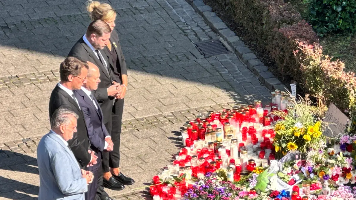 Zusammen mit der Spitze der NRW-Landesregierung und dem Solinger Bürgermeister Tim Kurzbach legt Kanzler Olaf Scholz am Ort des Anschlags in Solingen im Gedenken an die Opfer eine Blume ab.