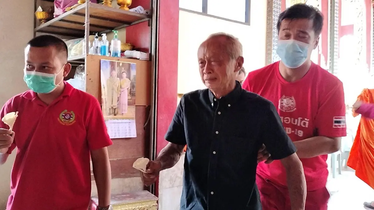 Charn Janwatchakal  aus Bangkok wird von Männern gestützt