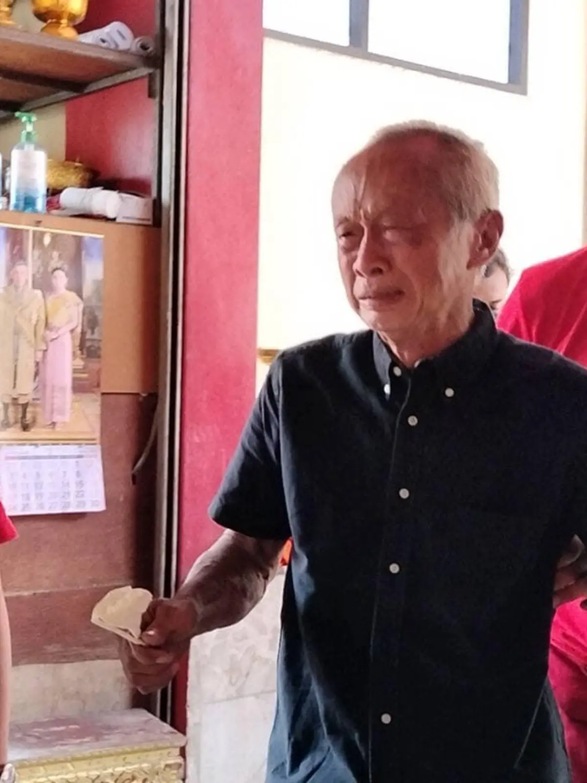 Charn Janwatchakal  aus Bangkok wird von Männern gestützt