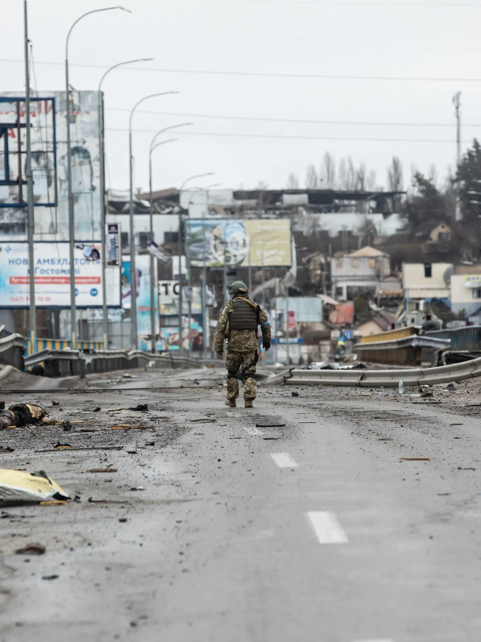 02.04.2022, Ukraine, Bucha: Ein ukrainischer Soldat geht entlang von Leichen auf einer zerstörten Straße. Fast 300 Zivilisten wurden entlang der Straße Butscha, einer Pendlerstadt außerhalb der Hauptstadt, getötet. Die meisten Opfer versuchten, den Fluss Buchanka zu überqueren, um in das ukrainisch kontrollierte Gebiet zu gelangen, und wurden dabei getötet. Russland ist am 24. Februar 2022 in die Ukraine einmarschiert und hat damit den größten Militärangriff in Europa seit dem Zweiten Weltkrieg ausgelöst. Foto: Mykhaylo Palinchak/SOPA Images via ZUMA Press Wire/dpa +++ dpa-Bildfunk +++
