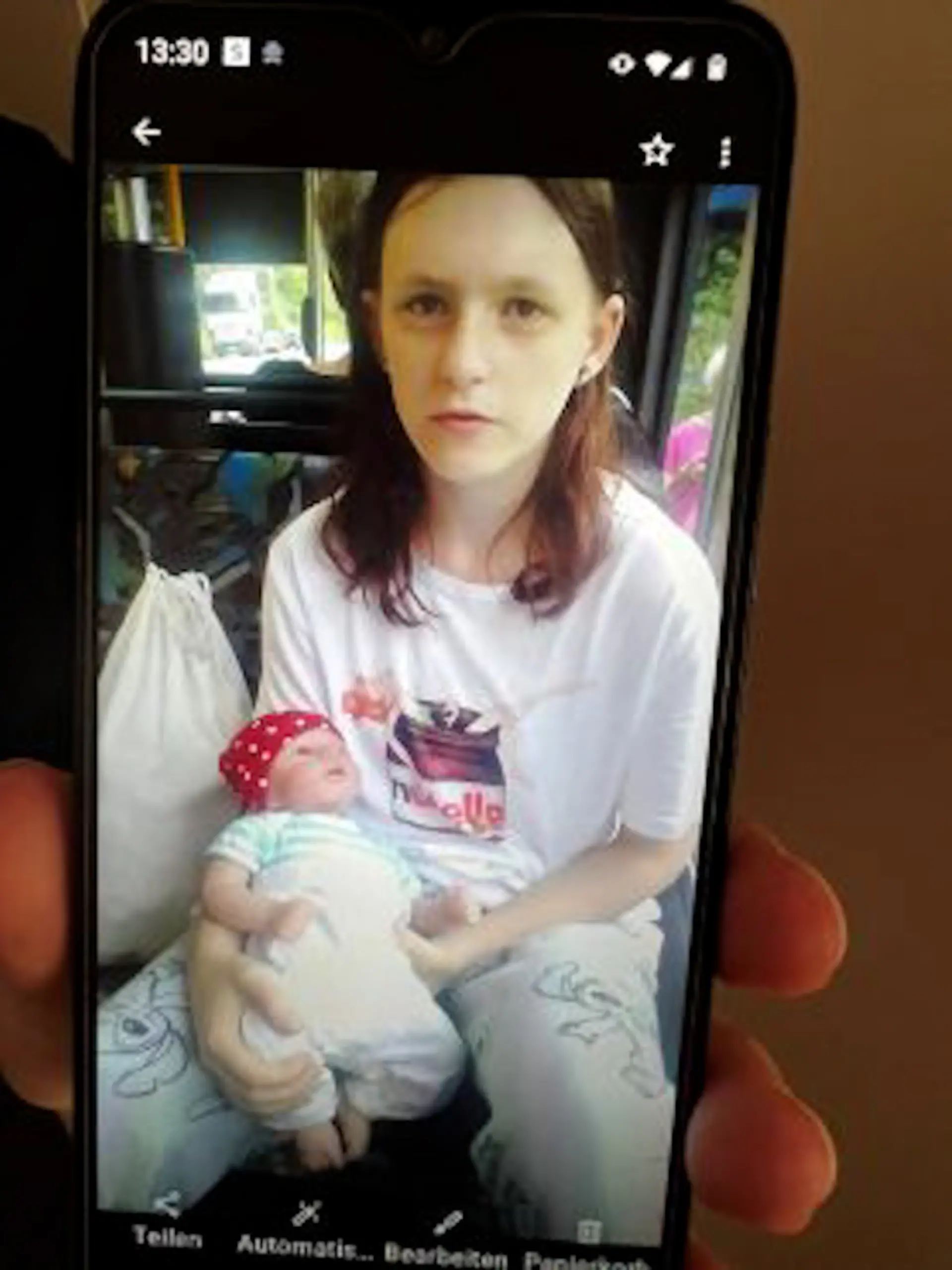 Auf dem Bild ist eine Jugendliche zu sehen, die allerdings Kleidung im Stil eines Kindes trägt. Sie hat eine Puppe in der Hand.