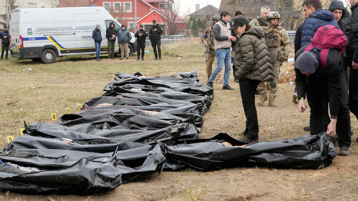 ARCHIV - 08.04.2022, Ukraine, Butscha: Iryna Wenediktowa (M), Generalstaatsanwältin der Ukraine, betrachtet exhumierte Leichen aus einem Massengrab. Sie steht an vorderster Front in einem weltweiten juristischen Kampf, um Russland zur Rechenschaft zu ziehen. Ihr Büro hat über 8.000 strafrechtliche Ermittlungen im Zusammenhang mit dem Krieg eingeleitet und über 500 Verdächtige identifiziert. Foto: Efrem Lukatsky/AP/dpa +++ dpa-Bildfunk +++