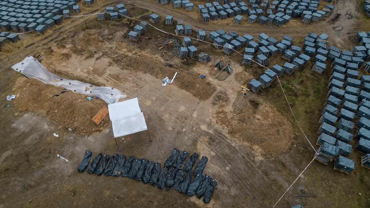 08.04.2022, Ukraine, Butscha: *** ATTENTION EDITORS GRAPHIC CONTENT *** Schwarze Plastiksäcke mit Leichen, die aus einem Massengrab exhumiert wurden, liegen aufgereiht in Butscha. Foto: Rodrigo Abd/AP/dpa - *** ATTENTION EDITORS GRAPHIC CONTENT *** +++ dpa-Bildfunk +++