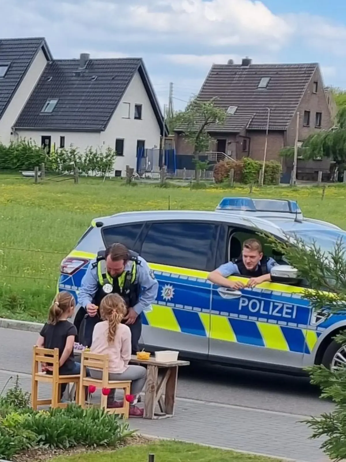 In Xanten kaufen Polizisten zwei Mädchen Blumen ab.