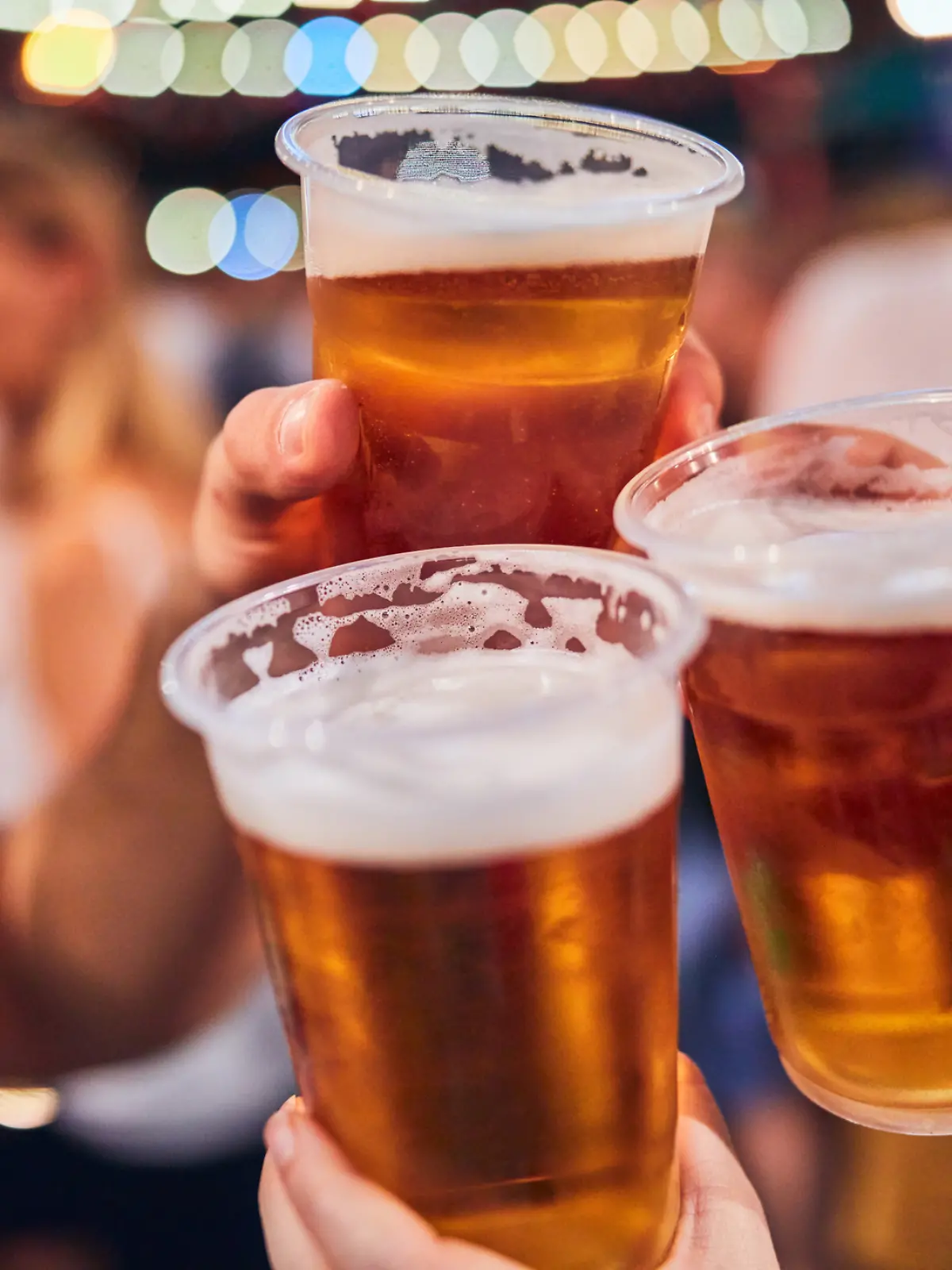 Eine Freundesgruppe stößt auf einer Feier mit Bier an. 