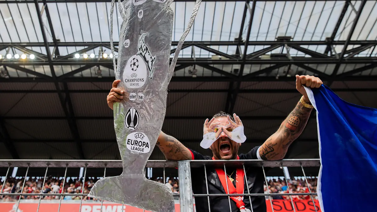 Fußball: Bundesliga, 1. FC Köln - VfL Wolfsburg, 33. Spieltag, RheinEnergieStadion. Ein Fan von Köln hält einen Ausschnitt des Europa-League-Pokals vor dem Spiel.
