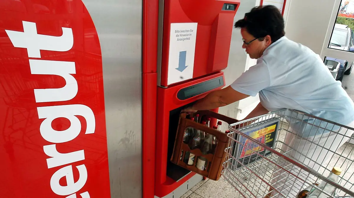 ARCHIV - Eine Frau stellt im oberpfälzischen Regensburg einen Kasten mit leeren Flaschen in einen Pfandautomaten (Archivfoto vom 24.07.2003).  Trotz Einführung des 25-Cent-Pflichtpfandes auf Einwegflaschen Anfang 2003 haben sich die Verbraucher Untersuchungen zufolge immer mehr von Mehrweg-Getränkeflaschen abgewandt. Das bestätigten laufende Erhebungen, sagte der Experte der GfK- Marktforschungs-Gesellschaft (Nürnberg), Birnbaum, der Deutschen Presse-Agentur dpa. Die Deutsche Umwelthilfe (DUH) sieht die Mehrweg-Systeme akut bedroht. Sie forderte deshalb neben dem Pflichtpfand weitere 20 Cent als Klimaschutzabgabe auf Getränkedosen, PET-Plastik und sonstige ökologisch nachteilige Einweg-Getränkeverpackungen. Foto: Armin Weigel dpa/lbn (zu dpa 0508) +++(c) dpa - Bildfunk+++