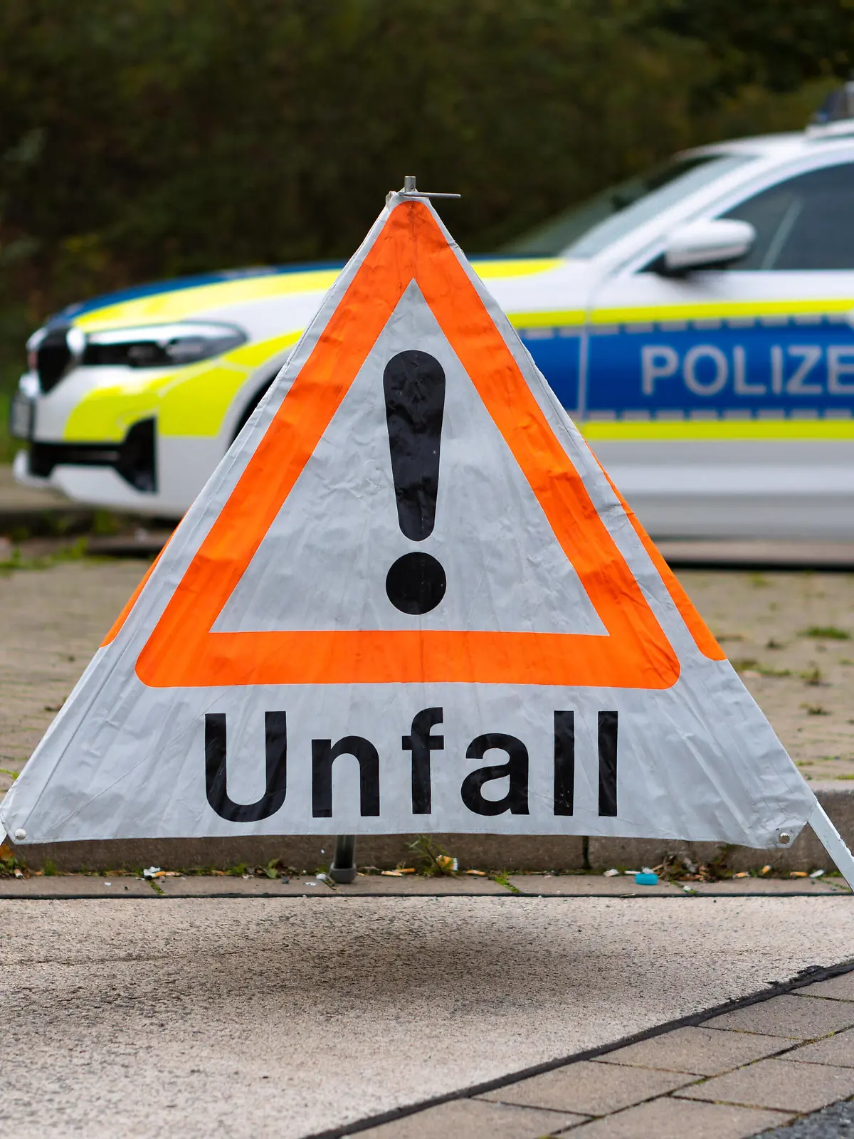  Deutschland 13. Oktober 2022: An einer Straße steht ein faltbares Warndreieck der Polizei mit der Aufschrift Unfall. Im Hintergrund steht ein Einsatzfahrzeug, Streifenwagen der Polizei mit Blaulicht und Schriftzug. Niedersachsen *** Germany 13 October 2022 On a road is a foldable warning triangle of the police with the inscription accident In the background is an emergency vehicle, police patrol car with blue lights and lettering Lower Saxony Copyright: xFotostandx/xGelhotx