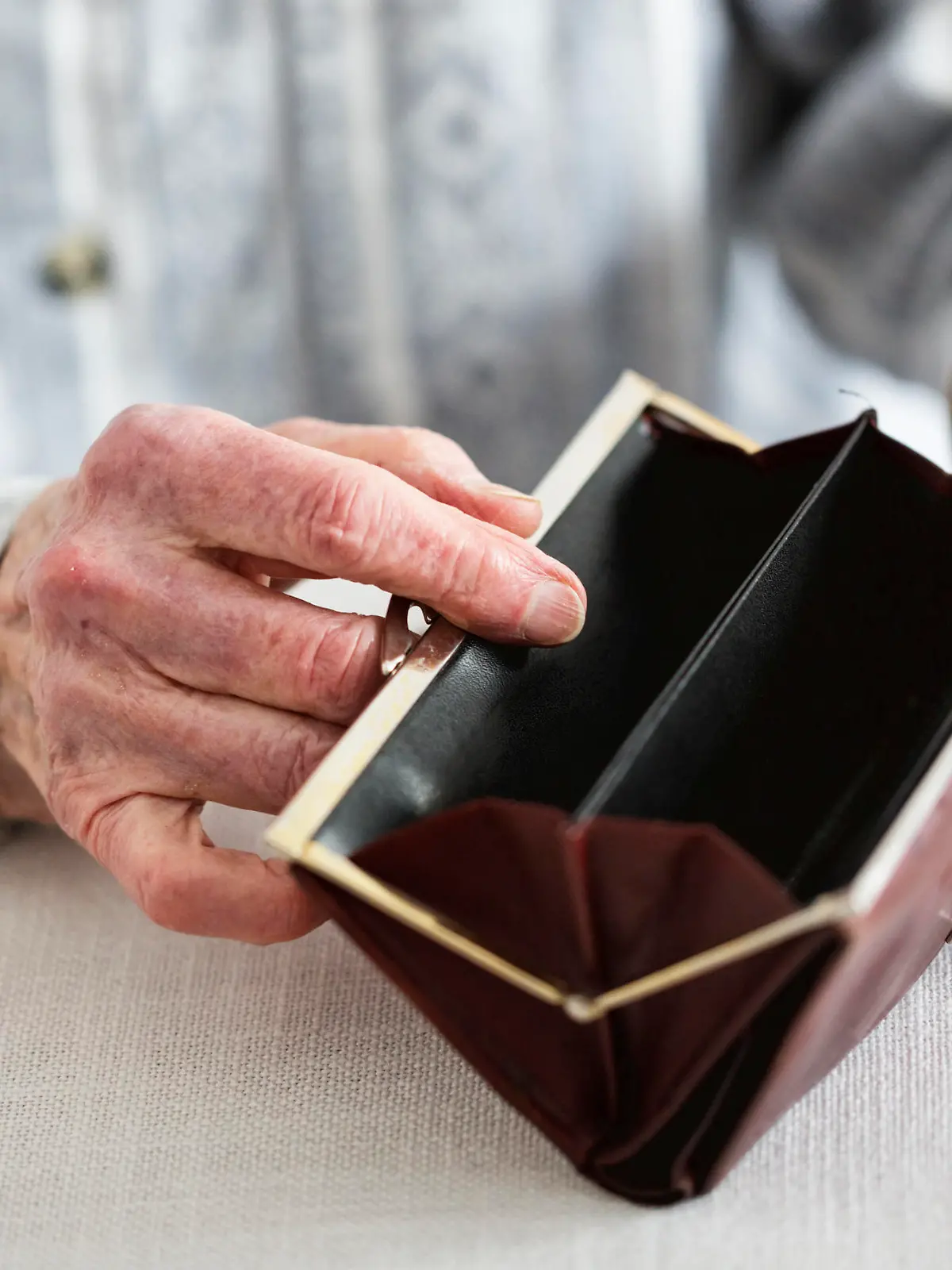Hands of senior woman, 90 years old, holding empty purse