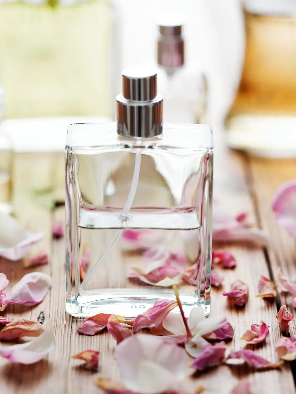 selection of perfume bottles surrounded by flower petals