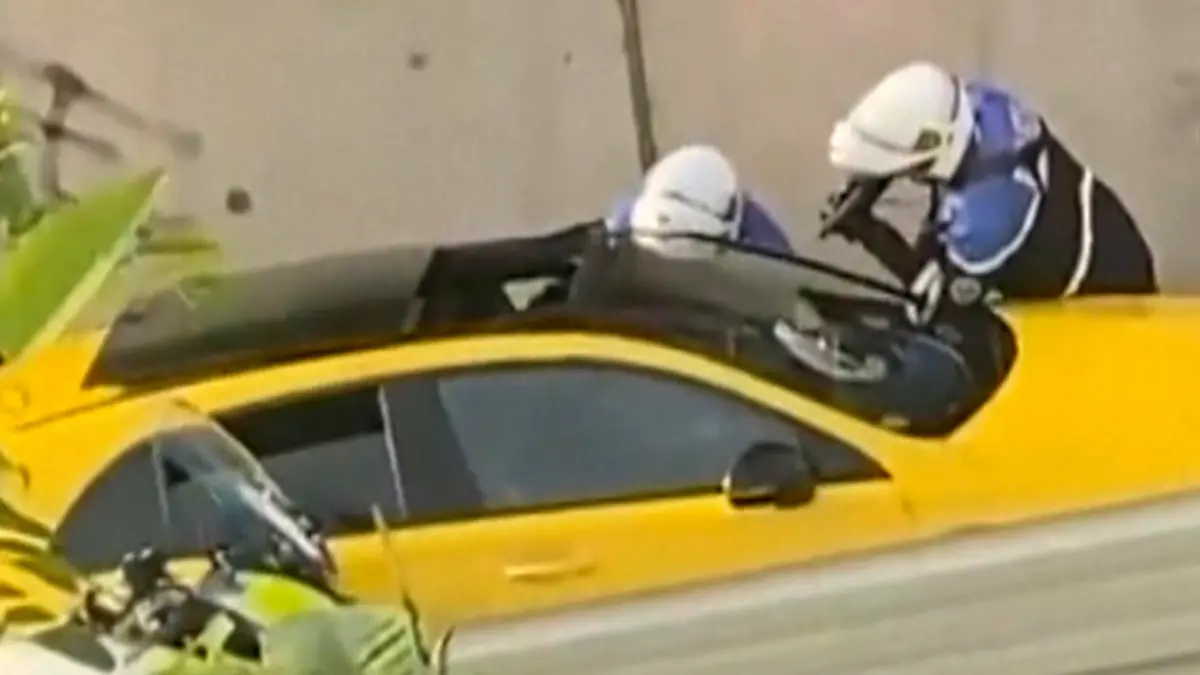 SCREENSHOT - 28.06.2023, Frankreich, Nanterre: In diesem von @Ohana_FNG zur Verfügung gestellten Videostandbild befragen zwei Polizeibeamte einen Fahrer, wobei ein Polizist eine Waffe auf das Fenster des gelben Autos richtet. Nach einem tödlichen Polizeischuss auf einen 17-Jährigen bei einer Verkehrskontrolle ist Frankreich in Aufruhr. Die französische Regierung hat eine verstärkte Polizeipräsenz in Paris und anderen Großstädten angekündigt und zur Ruhe aufgerufen. Foto: Uncredited/@Ohana_FNG/AP/dpa - ACHTUNG: Nur zur redaktionellen Verwendung im Zusammenhang mit der aktuellen Berichterstattung und nur mit vollständiger Nennung des vorstehenden Credits +++ dpa-Bildfunk +++