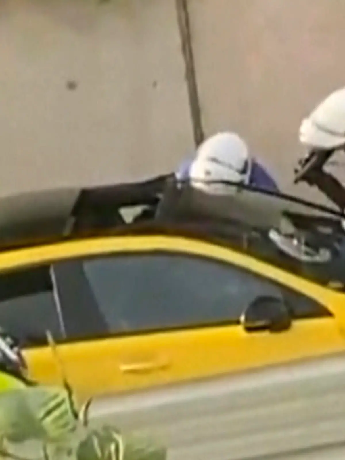 SCREENSHOT - 28.06.2023, Frankreich, Nanterre: In diesem von @Ohana_FNG zur Verfügung gestellten Videostandbild befragen zwei Polizeibeamte einen Fahrer, wobei ein Polizist eine Waffe auf das Fenster des gelben Autos richtet. Nach einem tödlichen Polizeischuss auf einen 17-Jährigen bei einer Verkehrskontrolle ist Frankreich in Aufruhr. Die französische Regierung hat eine verstärkte Polizeipräsenz in Paris und anderen Großstädten angekündigt und zur Ruhe aufgerufen. Foto: Uncredited/@Ohana_FNG/AP/dpa - ACHTUNG: Nur zur redaktionellen Verwendung im Zusammenhang mit der aktuellen Berichterstattung und nur mit vollständiger Nennung des vorstehenden Credits +++ dpa-Bildfunk +++