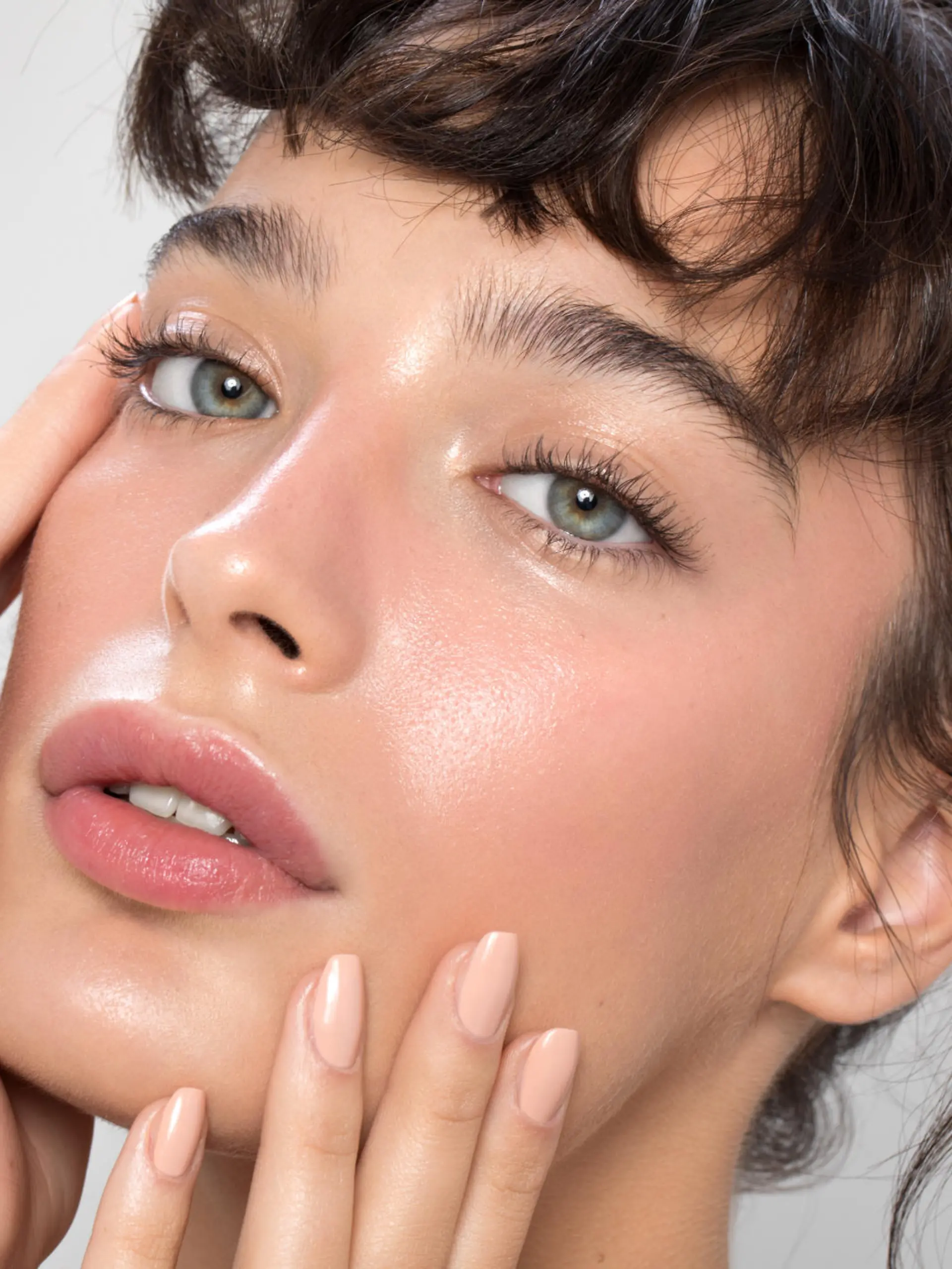 Close up studio shot of a beautiful woman with perfect skin, she touching her face