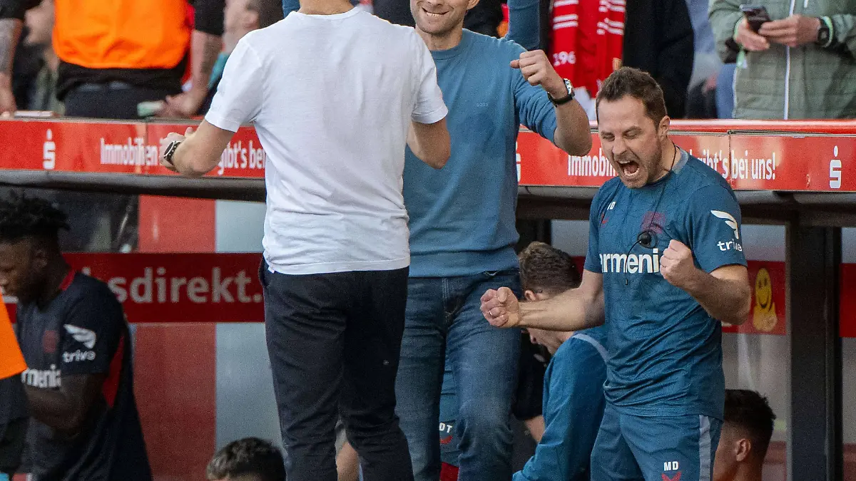 Leverkusens Trainer Xabi Alonso mit Sportdirektor Simon Rolfes und dem jubelnden Spielanalysten Marcel Daum