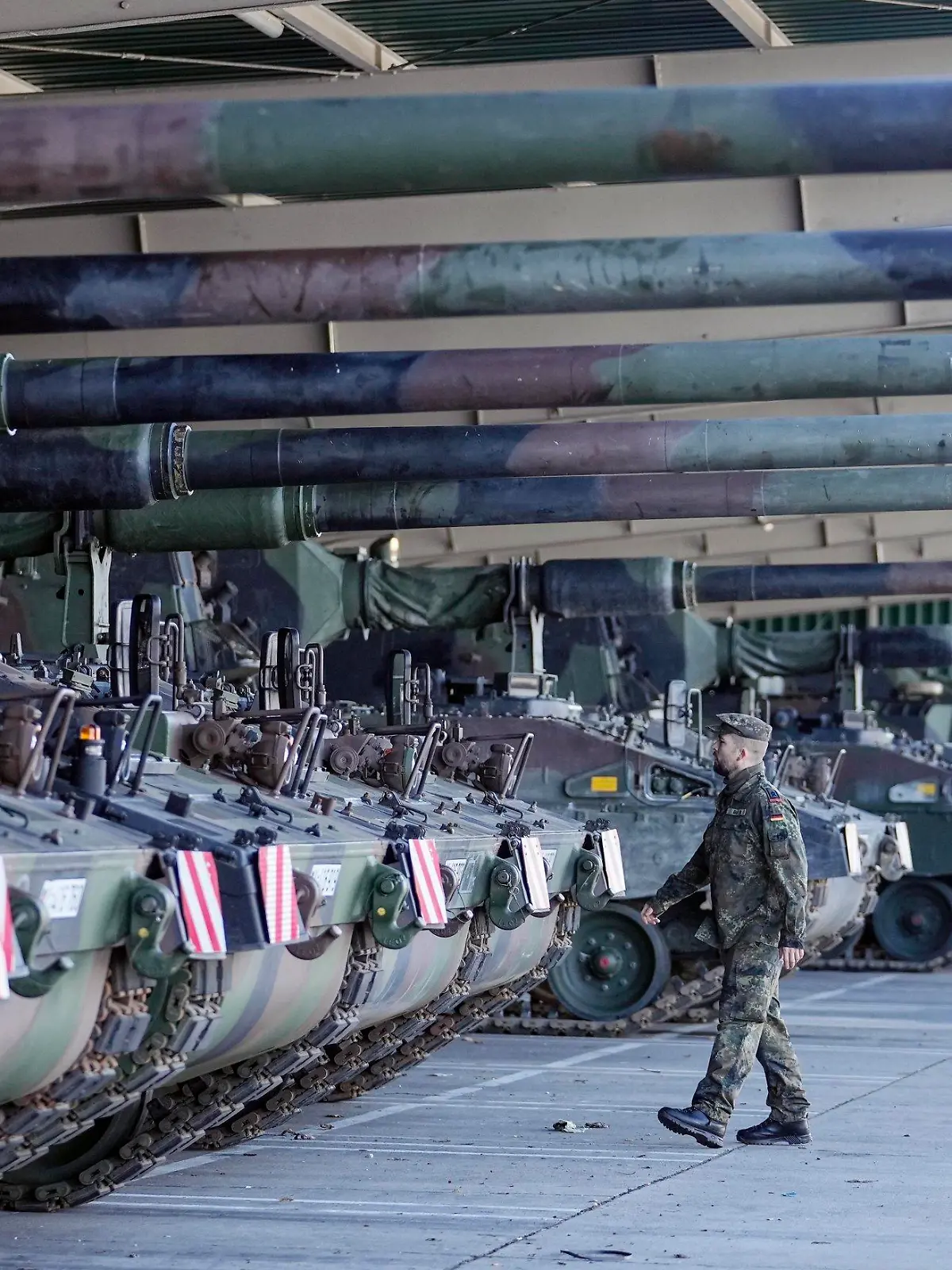 FILE - German soldiers walk beside tank howitzers 2000 prior transport to Lithuania at the Bundeswehr army base in Munster, northern Germany, Monday, Feb. 14, 2022. Germany's defense minister confirmed Friday that her country will supply Ukraine with seven powerful self-propelled howitzers to help defend itself against Russia. Christine Lambrecht said Ukrainian soldiers will be trained in Germany to use the self-propelled Panzerhaubitze 2000 artillery, which is capable of firing precision ammunition at a distance of up to 40 kilometers (25 miles). (AP Photo/Martin Meissner, File)