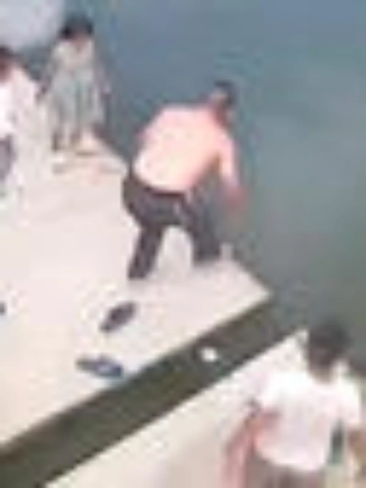 Ein Mann rettet ein ertrinkendes Mädchen aus einem Fluss.