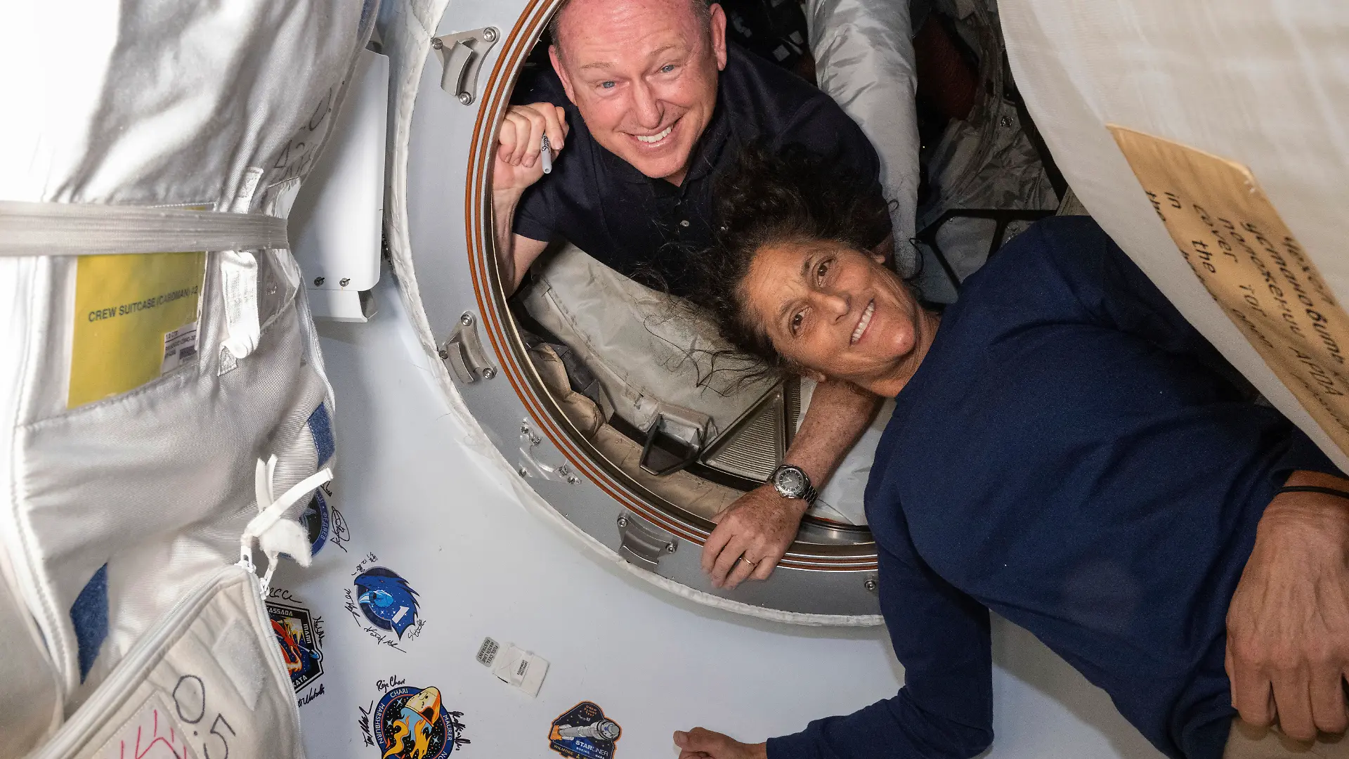 Die Astronauten Butch Wilmore und Suni Williams befinden sich an Bord der ISS und lächeln in die Kamera.