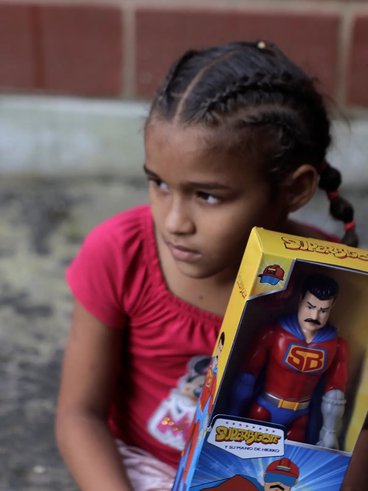Ein Kind hält eine „Super Bigote“-Aktionspuppe, die Präsident Nicolas Maduro nachempfunden ist, in der Hand. 