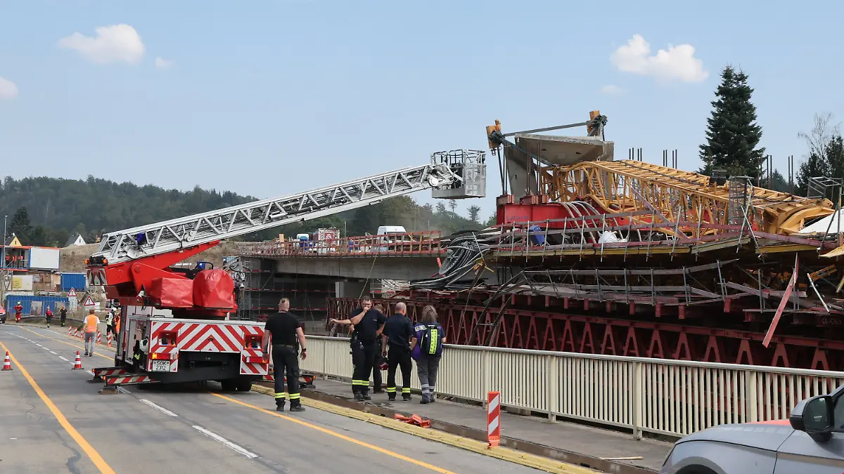 Ein umgestürzter Baukran, davor ein Feuerwehrauto.
