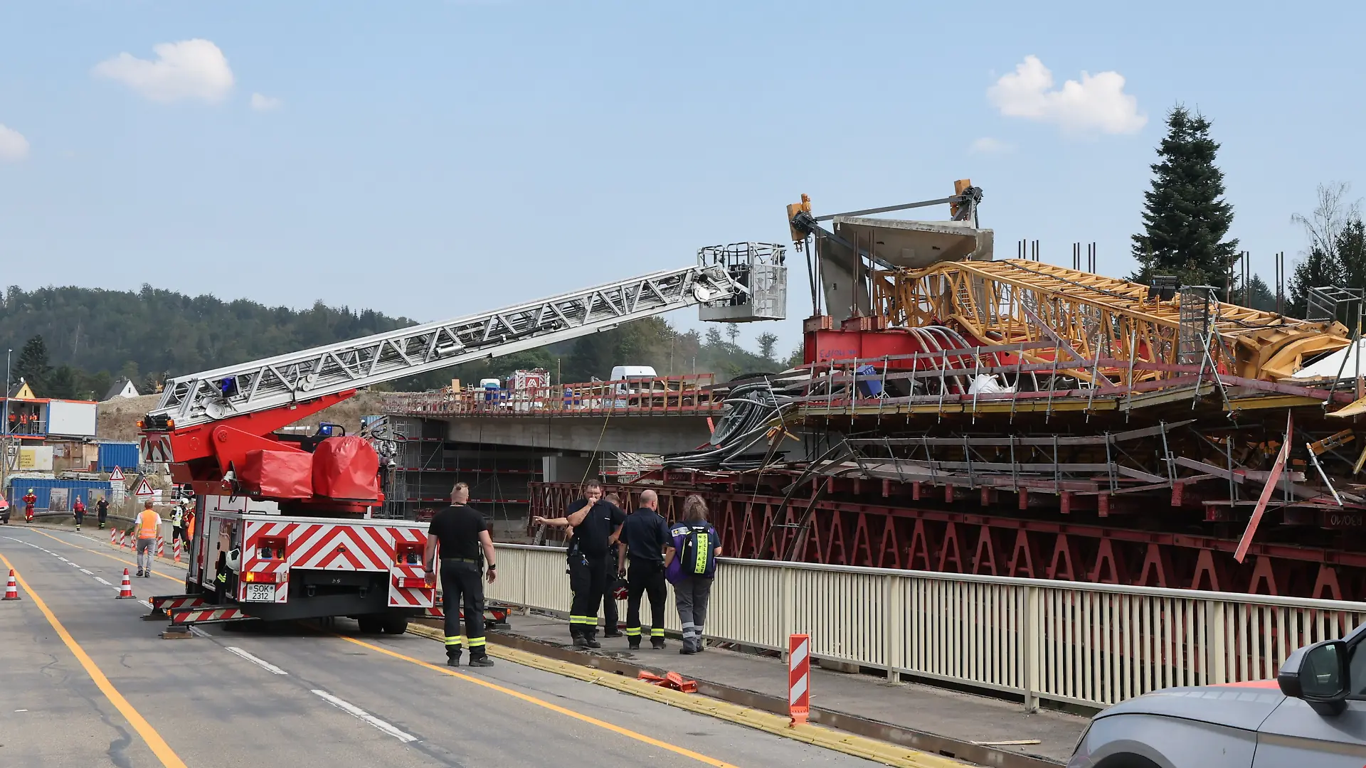 Ein umgestürzter Baukran, davor ein Feuerwehrauto.