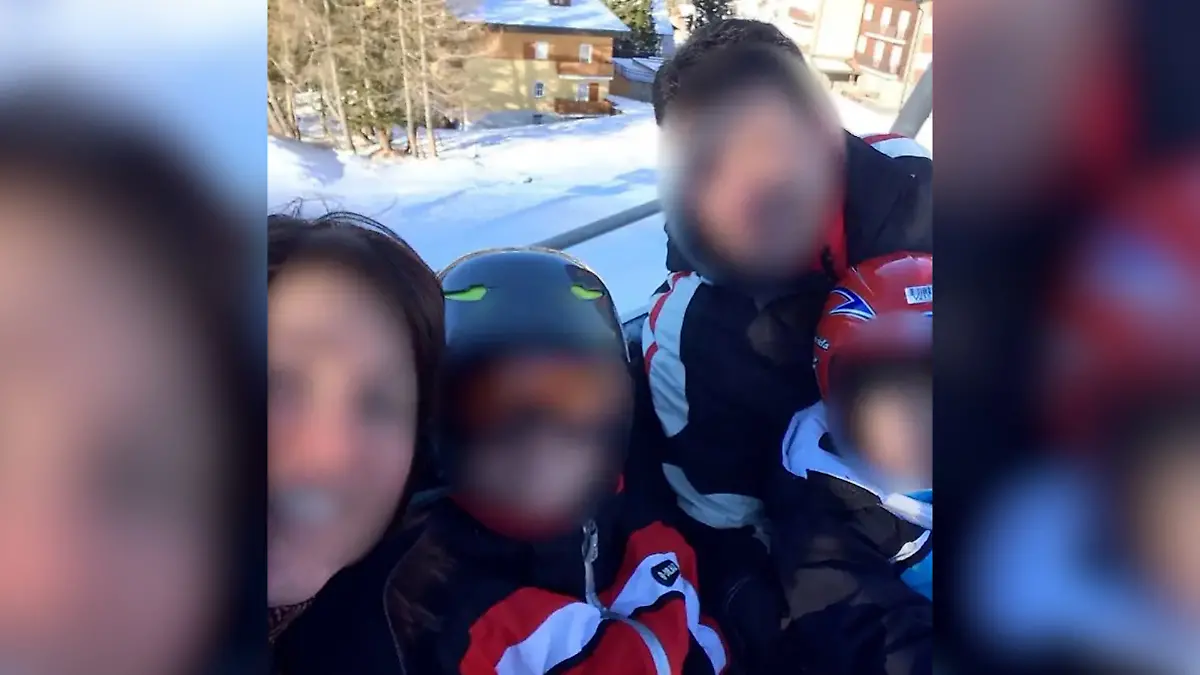Die Familie ist im Skiurlaub. In Skisachen schauen sie in die Kamera. Die Gesichter aller Personen sind unkenntlich gemacht.