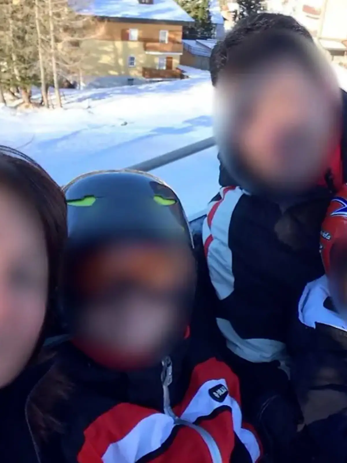 Die Familie ist im Skiurlaub. In Skisachen schauen sie in die Kamera. Die Gesichter aller Personen sind unkenntlich gemacht.